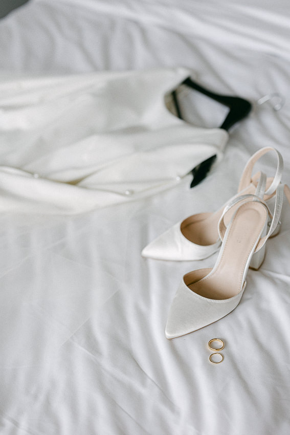 Les accessoires de la mariée : alliances, chaussures et robe de mariage.