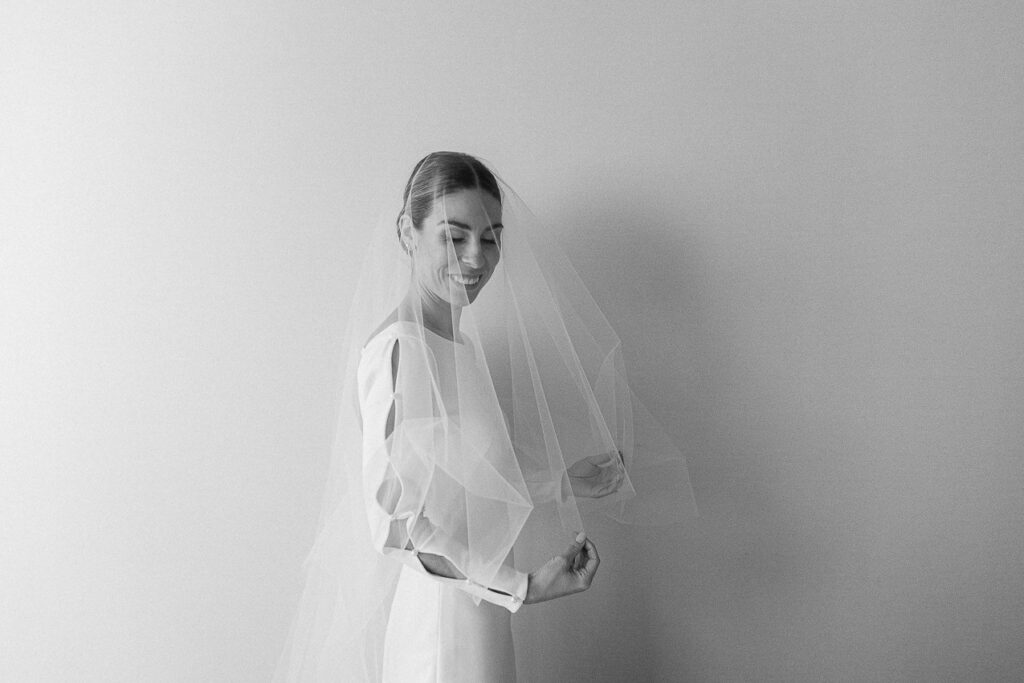 Portrait de la mariée dans sa jolie robe de mariage au look minimal, de la boutique de robes de mariée Dress Scoop.