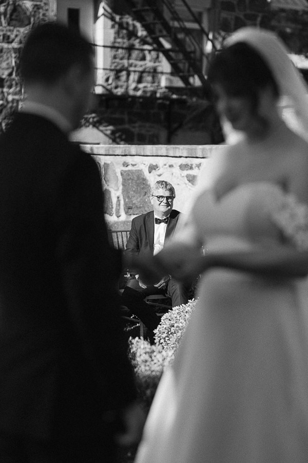 Le père du marié regarde l'échange des anneaux.