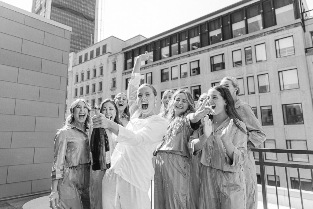 La mariée souriante entourée de ses demoiselles d'honneur. Elles pop le champagne !