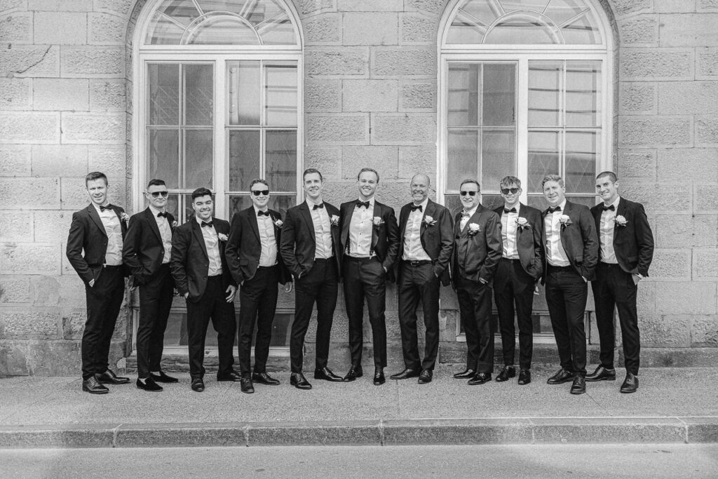 Portrait du marié et de tous les hommes du cortège. Ils sont tous élégants dans leurs tuxedo. 