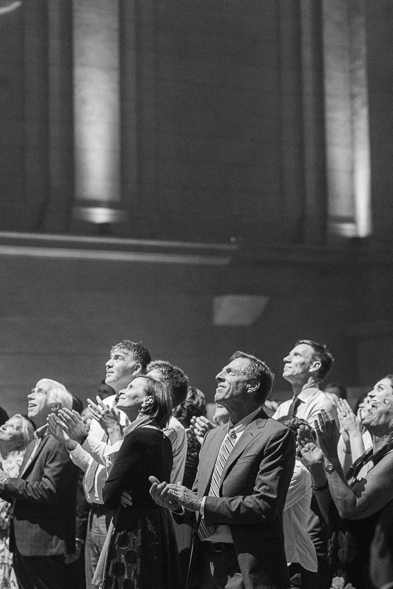 Les invités regardent vers le balcon pour le discours des mariés.