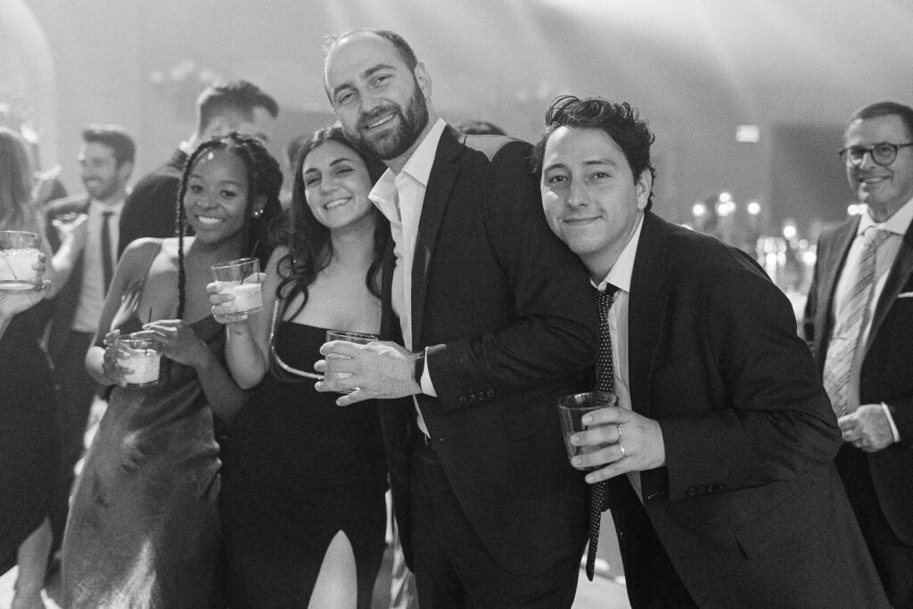 Portrait d'un groupe d'invités sur le plancher de danse lors de la réception de mariage.