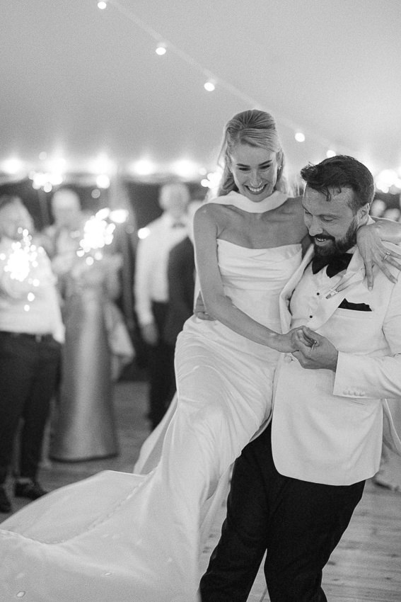 Le marié soulève la mariée lors de la première danse dans la salle de réception du mariage